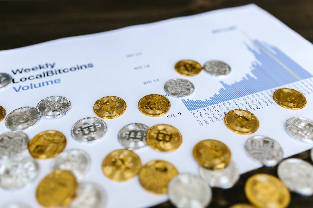 about-us Gold and silver Bitcoin coins placed on a graph showing LocalBitcoins trading volume analysis, symbolizing cryptocurrency market trends.